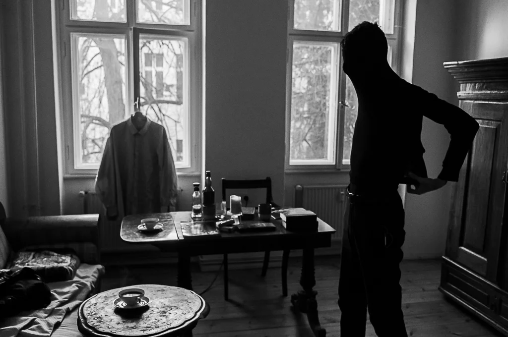 Schwarzweiß Porträt eines mannes in stilvollem Interieur mit natürlichem Licht durch große Fenster